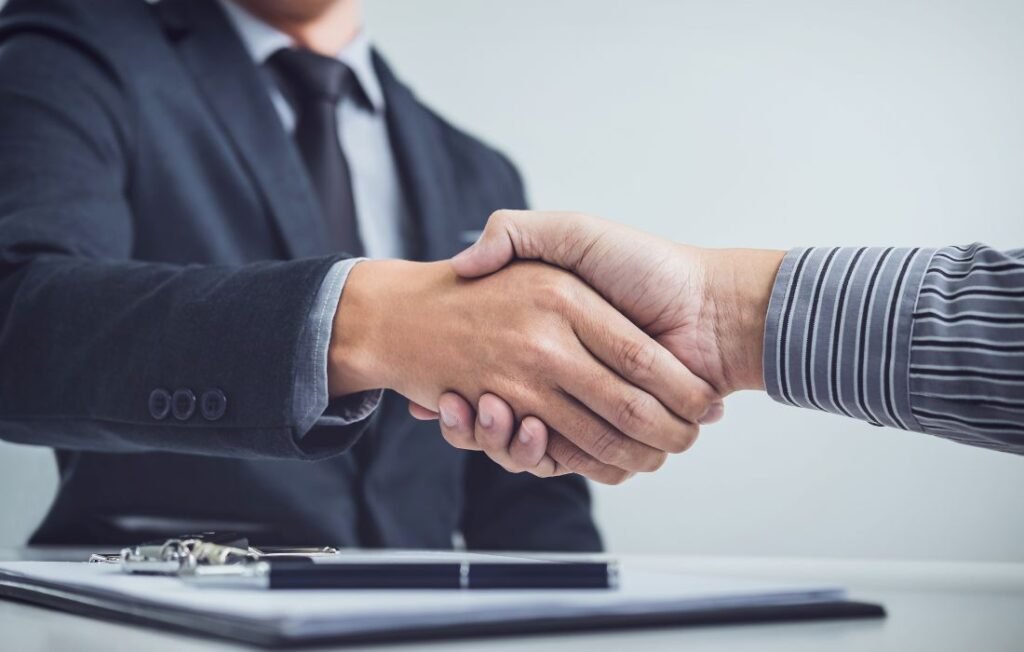 two persons shaking hands for a buy and sell agreements